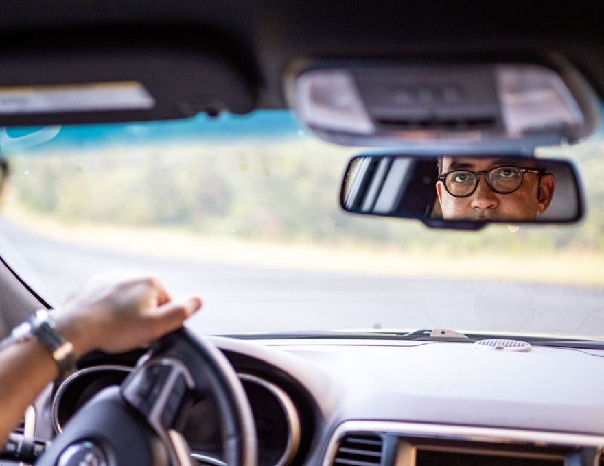 Will Hurd driving a car. View from the rear seat